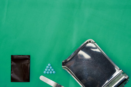 round pills ,zip bag,spatula and pharmacy tray on surgery green medical background with copy spaceの写真素材