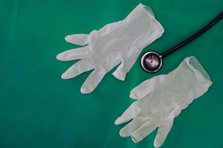 Stethoscope with gloves on green surgery background in medical healthcare concept with copy spaceの写真素材