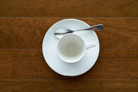 ceramic tea or coffee cup with spoon and plate on wooden paletteの写真素材