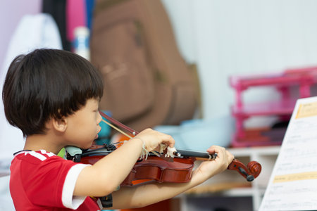 boy plays violin on blur background with note stand in covid-19 crisis quarantine time periodの写真素材