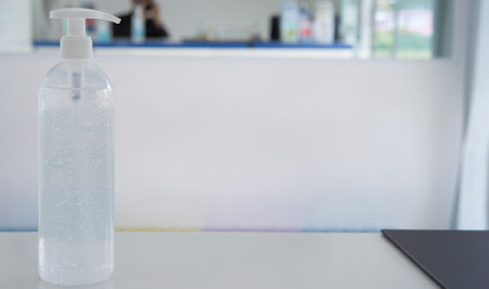 pumping alcohol gel bottle on recepteion counter with copy spaceの写真素材