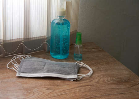 pile of charcoal face masks ,alcohol gel bottle and alcohol spray on wooden table for bring together...