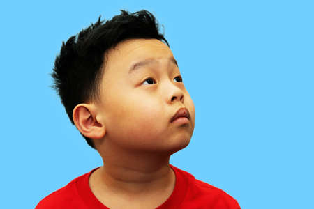 asia boy headshot look upward isolated on blueの写真素材