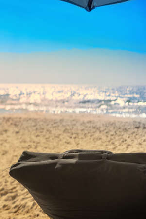 empty beach chair at sand and blue sea in tropical sceneの写真素材