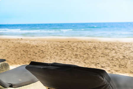 empty beach chair at sand and blue sea in tropical sceneの写真素材
