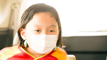Asia boy wear protective mask in car travel in quarantine coronavirus Covid-19 pandemic in car cabinの写真素材