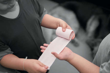 elastic roll gauze bandage hold in hand with adhesive for first aid compress care for accident...