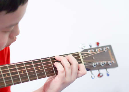 Asian boy playing guitar And look down at the hands that are holding the chords, play a song