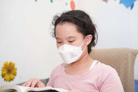Bangkok,Thailand,June 27,2021-asia young girl wear protect mask reading book in homeのeditorial素材