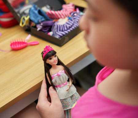 Bangkok,Thailand,Aug 30,2021-barbie doll Dress up in a strapless evening gown and wear a crown. Children's toys. hold by blurry kid foregroundÂ のeditorial素材