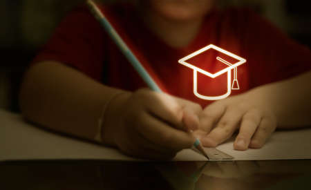 asian boy kid concentrate to write and draw homework before back to school in learning indoor education lessonの写真素材