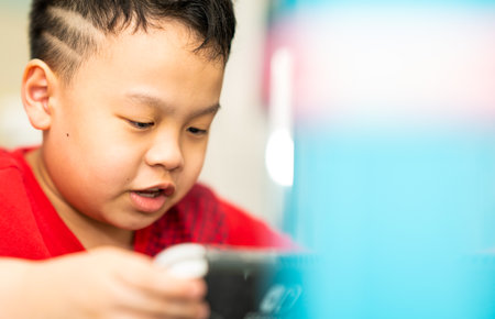 boy sit down and play portable game consoleの写真素材