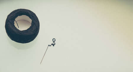 black thread and sewing needle placed on the tableの写真素材