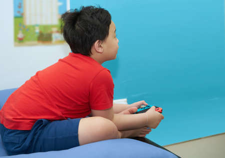 Boy use joystick controller play game in room houseの写真素材