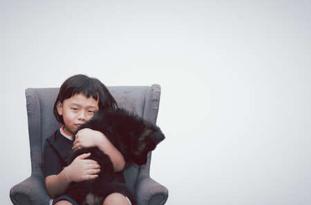 asia boy sit on armchair and hug pet dog with happy isolated on white copy spaceの写真素材