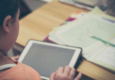 kid is learning online internet lesson learning from school teacher by tablet and do homework on desk in coronavirus covid 19 quarantine pandemic conceptの写真素材