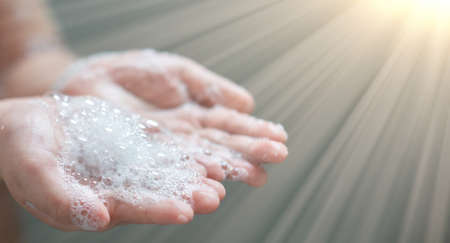hand hold bubbles in palm with lightの写真素材