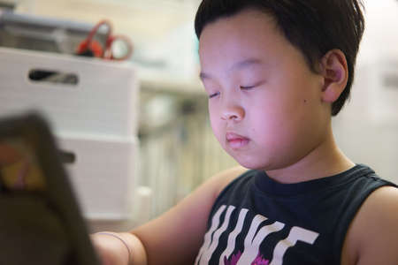 asia boy learn online by tablet notebook computer in qurantine covid 19