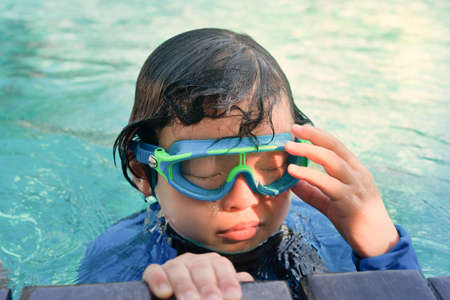 kid in goggles in swimming poolの写真素材