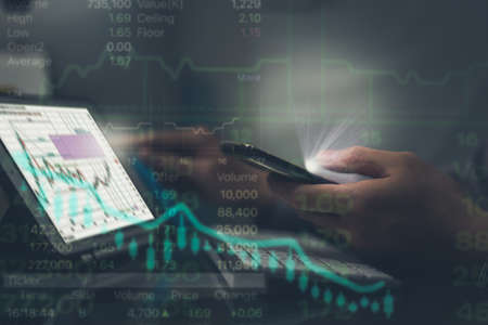 business man use technology tablet computer and cell phone to invest in stock for growth and see...