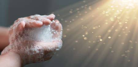 hand hold bubbles in palm with lightの写真素材