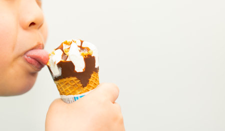 kid eating ice cream wafer cone with happinessの写真素材