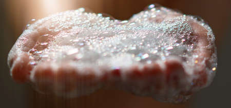 hand hold bubbles in palm with lightの写真素材