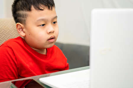 kid do education by online learning with laptop or tablet computer at home in quarantine called e-learning communication to teacher or tutorの写真素材