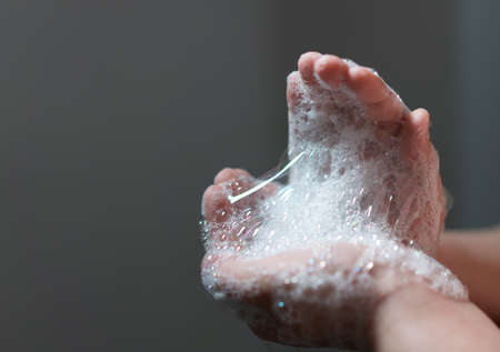 hand hold bubbles in palm with lightの写真素材