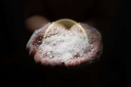 hand hold bubbles in palm with lightの写真素材