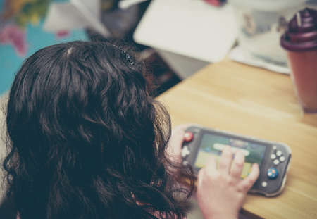 kid play portable online gamming console device by handheld with entertainment in room indoors toy in electronic child user conceptの写真素材