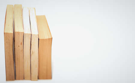 stacks of books arranged horizontally on white background high angle viewの写真素材