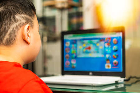 kid do education by online learning with laptop or tablet computer at home in quarantine called e-learning communication to teacher or tutorの写真素材