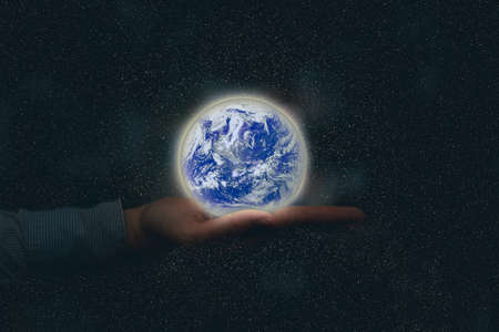Businessman or investor manage the world of business. using a glowing globe in global investment finance management conceptの写真素材