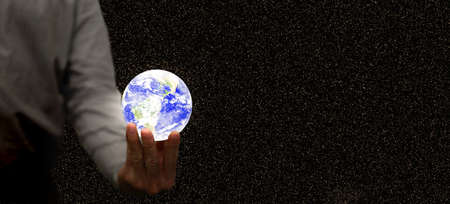 Businessman or investor manage the world of business. using a glowing globe in global investment finance management conceptの写真素材