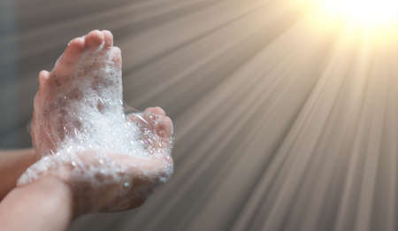 hand hold bubbles in palm with lightの写真素材