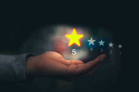 Hand hold five star represent excellent rating or quality in service business by customer in positive best review ranking conceptの写真素材
