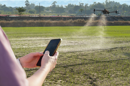 Woman using a mobile phone in a farm, surrounded by farm, control Agriculture Petrol Drone Sprayer .