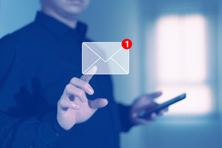 businessman press email screen for responding mail alert sign with blur holding smartphoneの写真素材