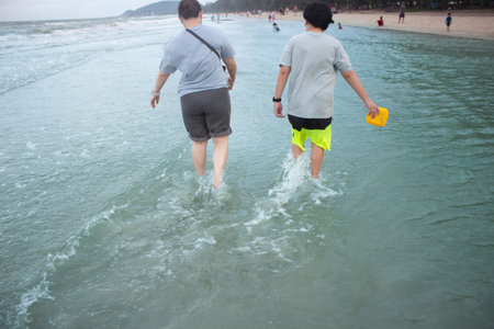 Two People Walking in Shallow Ocean Water