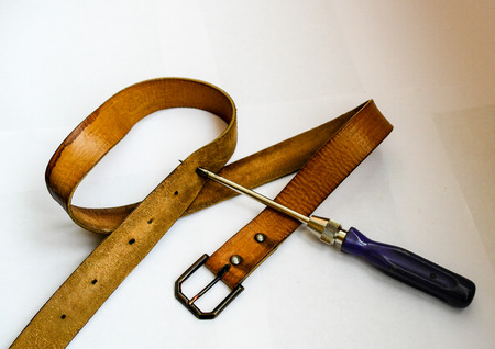 to make a new hole in the belt to tighten their beltsの写真素材