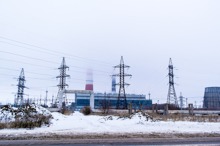 thermal power plant and transmission poles in winter in the fog