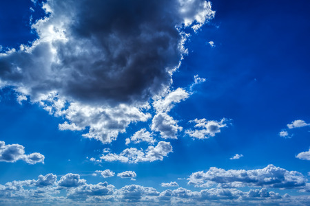 White and dark Cumulus clouds on a blue skyの写真素材