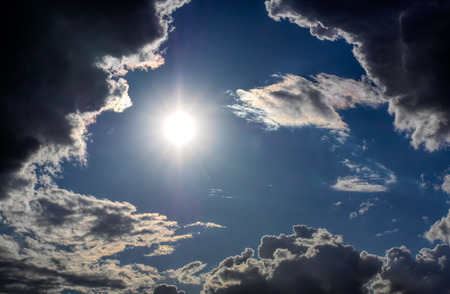 Sun and clouds on a blue skyの写真素材