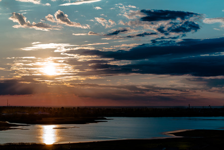 Sunset in the clouds above the Bay on a background of the blue skyの写真素材