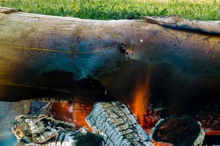 the trunk of the tree in the fire, burning coals, fire, smoke, sparksの写真素材