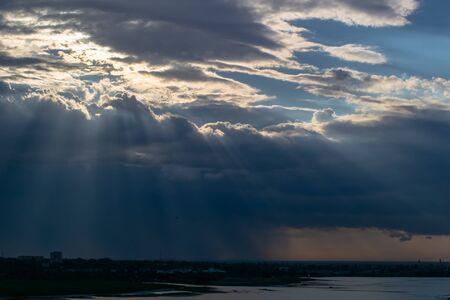 The Sun's rays that make their way through the dark cloudsの写真素材
