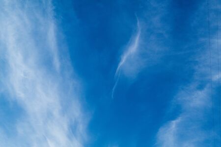 white Cirrus clouds on a blue sky above rural sceneryの写真素材