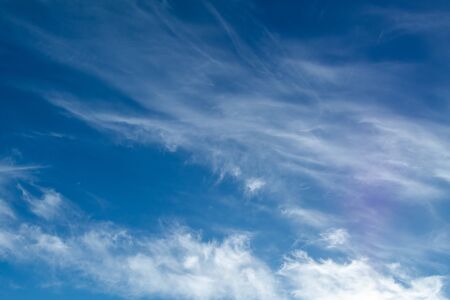 white Cirrus clouds on a blue sky above rural sceneryの写真素材