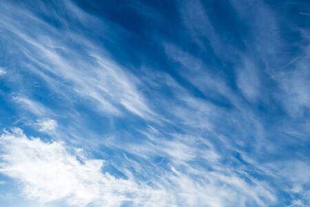 white Cirrus clouds on a blue sky above rural sceneryの写真素材
